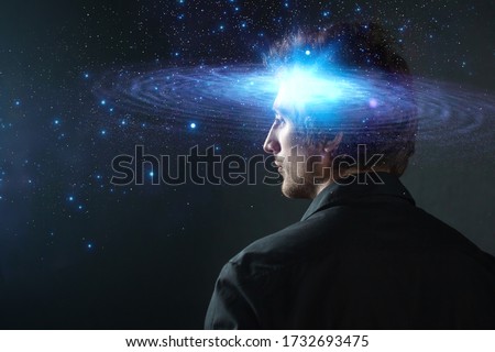Thoughtful young man, creative mind concept. A man with a galaxy in his head, complex human consciousness and psychology, inner space Royalty-Free Stock Photo #1732693475