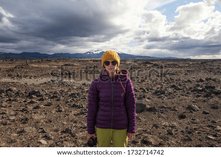 Happy tourist woman in bright coat , enjoying traveling Iceland