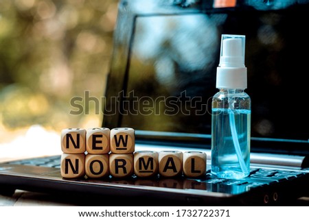 close up wooden text block and bottle of alcohol hand spray on computer, 2019-ncov risk and problem, coronavirus covid-19 warning, e-commerce and shopping online business, new normal lifestyle concept