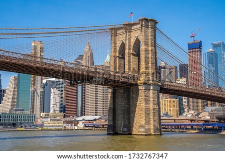 Brooklyn Bridge and the Lower Manhattan in New York City with clear blue sky.