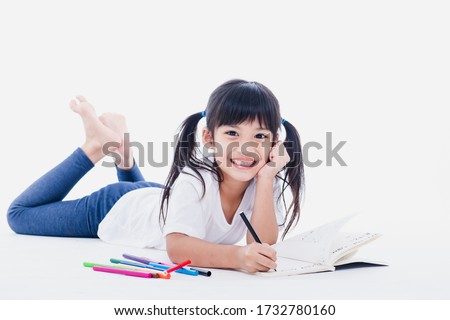 A young asian girl drawing a picture. On white