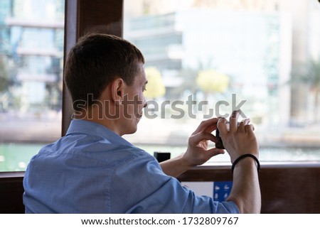 Tourist with a camera on a pleasure boat. Male tourist takes pictures of the city from pleasure boat
