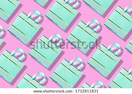 Top view of turquoise paper shopping bag pattern on trendy pink background. Copy space. Creative design for packaging. Gift concept. Woman's day. Valentine's day. Ready for birthday party