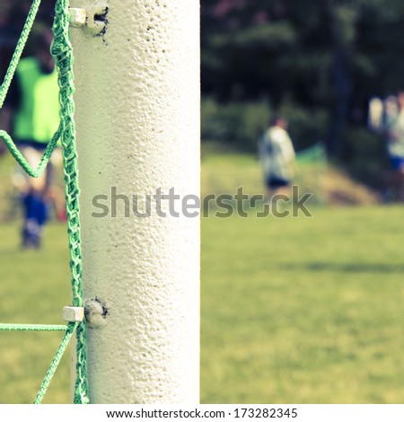 green football net, green grass and players