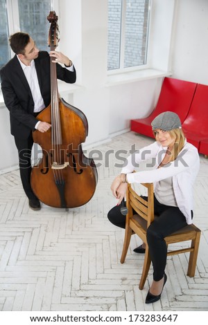 Woman sit backwards on chair and man play