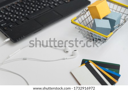 Laptop, earphones, shopping cart and credit cards. Online shopping and delivery concept horizontal photo