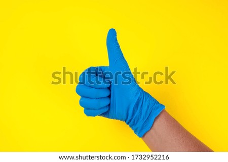 Hands in blue medical gloves showing thumbs up gesture. Medicine and healthcare concept