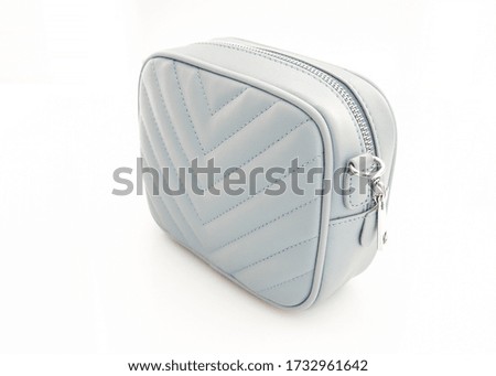 small blue cross body bag on a white background
