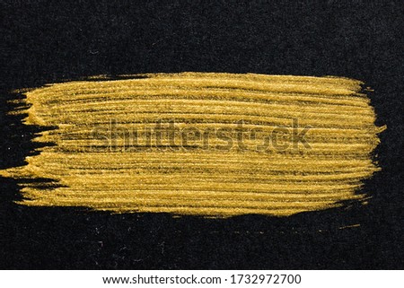 Textured gold smear paint brushes on the black.