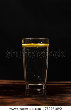 Lemon in glass of water om black background