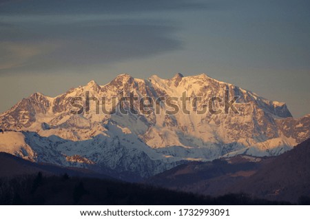 A breathtaking view of the snow-covered mountains under the dull sky