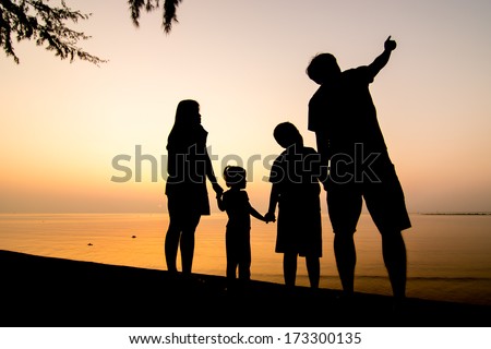 Silhouette of family on the beach at dusk.
