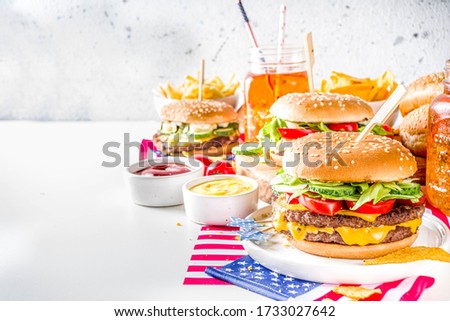 Celebrating Independence Day, July 4. Traditional American Memorial Day Patriotic Picnic with burgers, french fries and snacks, Summer USA picnic and bbq concept, White concrete background