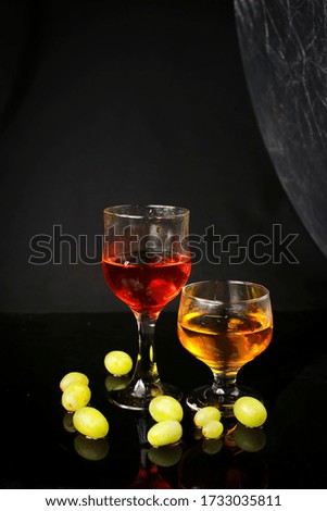 Water splash out of glass on a black background. With green grapes.