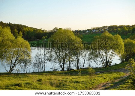 Beautiful countryside landscape. Green meadow and river in the evening. Summer. Russia.