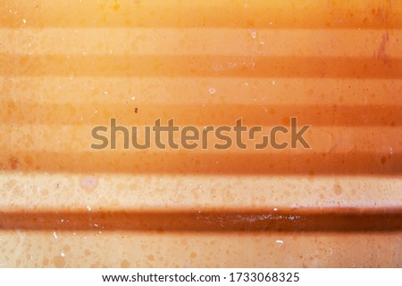 Texture of an orange metal barrel close-up