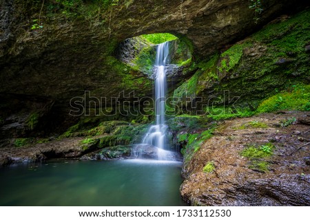 The fascinating waterfall in the forest: Deliklikaya Waterfall. Water flows through a hole formed by the erosion of lime and clay stone. Photo was taken in Murgul district of Artvin - Turkey.