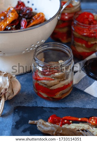 Homemade pepper preserves. Red roasted peppers with garlic and olive oil. Close up. Selective  focus.