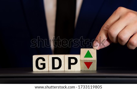 Hand is turning a dice and changes the direction of an arrow symbolizing that the GDP of a country is changing the trend and goes up instead of down Royalty-Free Stock Photo #1733119805