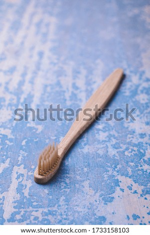 Bamboo toothbrush on blue wood background. Concept eco friendly