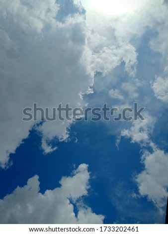 Blue sky background with sunlight and clouds pattern.