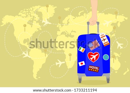 man hand is holding a blue Travel bag with sticker on the yellow world map and has airplane. Vacation time around the world. Enjoy international trip . Tourism, Journey concept. 