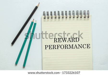 REWARD PERFORMANCE. marketing research target searching A cup of cappuccino, glasses, a marker, pen, three colored pencils and a notebook for writing