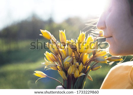spring mood and feeling of freedom. girl holding a bouquet of yellow wild tulips
