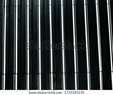 Vertical white fluorescent lamps on a black wall