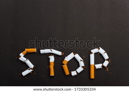 31 May of World No Tobacco Day, no smoking close up word STOP spelled text of the pile cigarette or tobacco on black background with copy space, and Warning lung health concept
