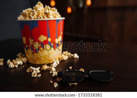 Popcorn in a bowl and 3d glasses on wooden background. Entetainement concept.