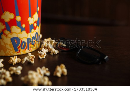 Popcorn in a bowl and 3d glasses on wooden background. Entetainement concept.