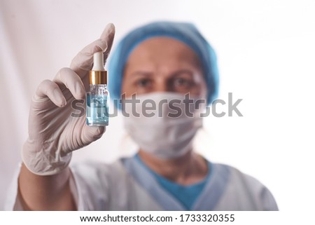 Doctor holds in his hands the drip with the drug.