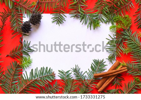 Christmas composition on red background. Paper blank, christmas tree branches, Copy space for text. Flatlay for designers. Top view, Greeting Card mock up. Royalty-Free Stock Photo #1733331275