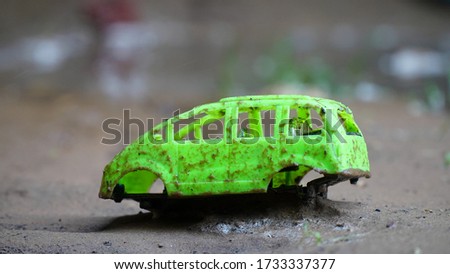 green toy car closeup view. dirty car melt with rain soil.