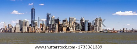 Panorama of Lower Manhattan of New York City with USA Flag from liberty island. This also known as Downtown Manhattan or Downtown New York the largest business district in state of New York and USA.
