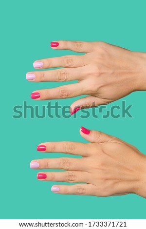 Closeup top view flatlay photography of two beautiful manicured female hands. Woman with trendy colorful 2 colours modern nail design of pink and purple colors made in professional beauty spa salon.