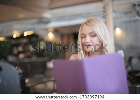 A selective shot of a female holding her tablet with violet case