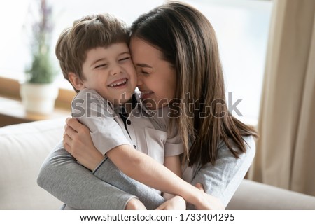 Happy young Caucasian mother hug cuddle cute little preschooler son enjoy tender time together at home, smiling mom embrace small boy child show love and care, bonding, family unity concept Royalty-Free Stock Photo #1733404295