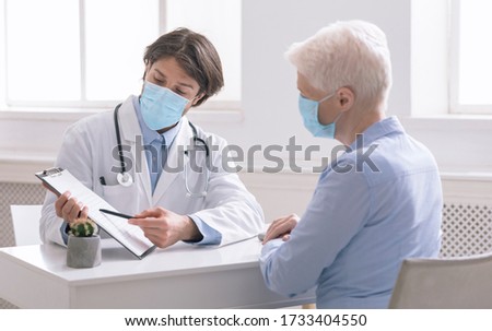 General practitioner showing analysis results to senior woman during preventive visit Royalty-Free Stock Photo #1733404550