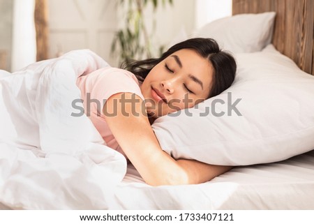 Asian Woman Sleeping Lying In Bed At Home Hugging Pillow On Weekend Morning. Healthy Sleep Concept Royalty-Free Stock Photo #1733407121