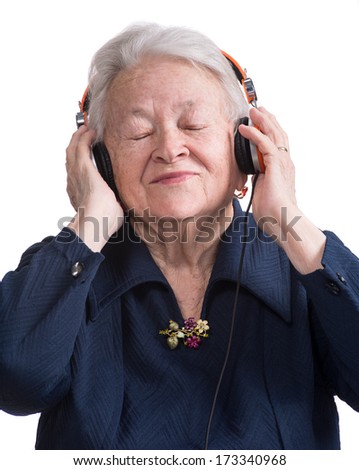 Old woman listening to music in headphones on a white background