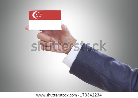 Businessman hand holding a business card with Singapore flag and clipping path