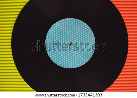 Black vinyl arranged on a red and green background seen from above