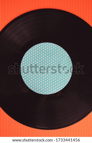 Black music vinyl on a red background top view