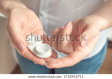 Eyesight and eyecare concept. Closeup Of Woman Hands Holding White Eyelense Container. Optics, Vision, Optical Instruments. Ophthalmology, medical.