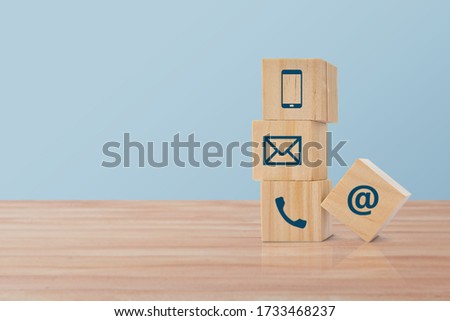wooden block cube with (telephone, email, address) icon. Concept of contact us or customer support theme.