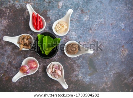 Shrimp paste, chilies, lemongrass, onion, garlic, kaffir lime leaves, turmeric
Placed on white spoon over a rusty iron floor, soft focus, copy space