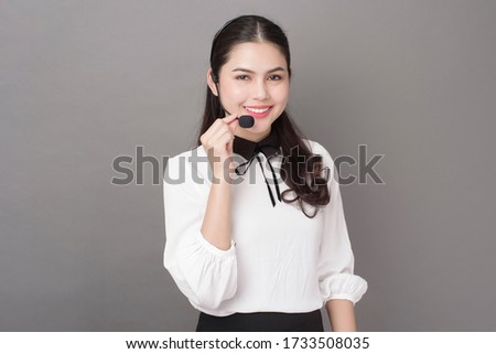 Portrait of beautiful operator woman on gray background 