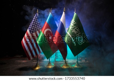 Business dialogue, oil agreement concept: National flags with Oil pump and oil refining factory at night. Energy industrial concept. Selective focus. Artwork decoration.